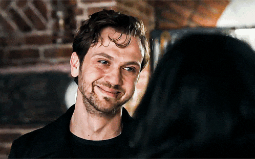 a man with a beard smiles at a woman