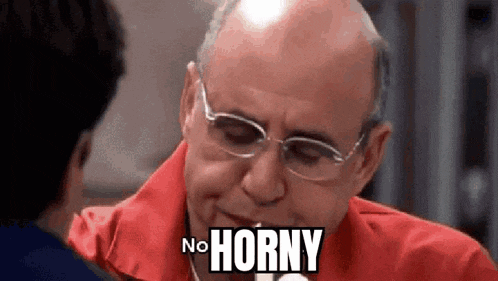 a bald man wearing glasses and a red shirt is talking to another man and says `` no horny '' .