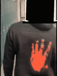 a man wearing a black hoodie with an orange hand print on the back