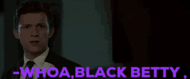 a man in a suit and tie is standing in a dark room and talking to someone .