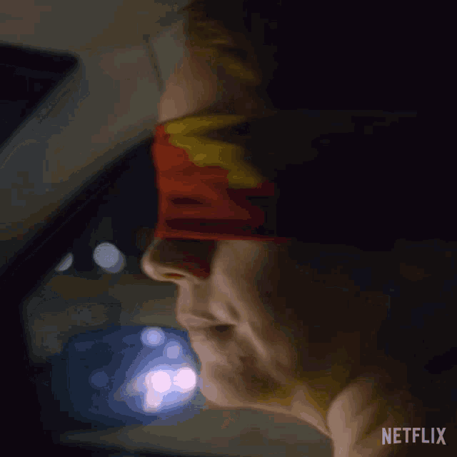 a woman is blindfolded in a car with a netflix logo on the bottom
