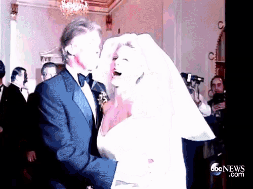 a man in a tuxedo kisses a woman in a wedding dress in front of abc news.com