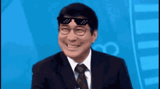 a man in a suit and tie is wearing sunglasses on his head