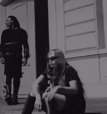 a black and white photo of a man and a woman with the man wearing a black shirt that says i 'm brutal