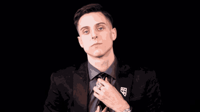 a man in a suit has a badge on his jacket that says ' a & g '