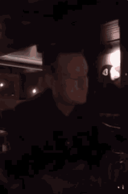 a man in a black shirt is sitting in a car