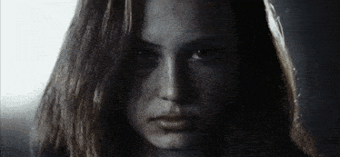 a close up of a woman 's face with a serious look on her face