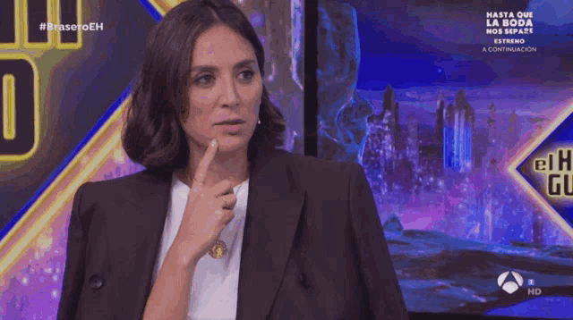a woman in a suit is making a face in front of a screen that says hasta que la boda nos separe