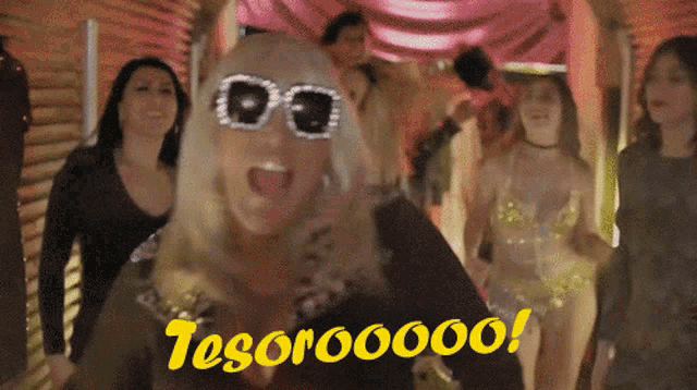a group of women are dancing and one of them is wearing sunglasses that say tesorooooo