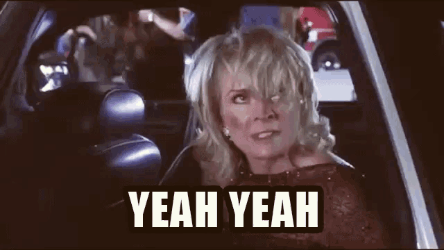 a woman is sitting in the back seat of a car and making a funny face .