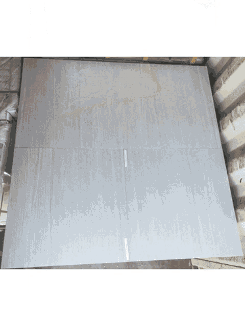 a large piece of gray tile is sitting on top of a stack of tiles