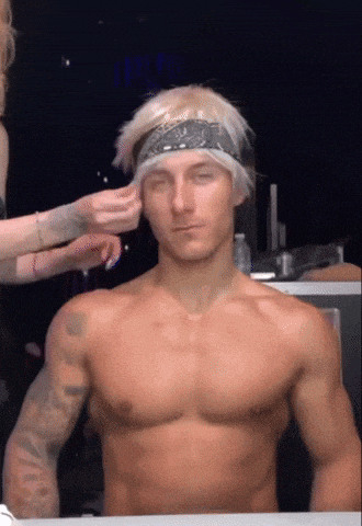 a shirtless man with a bandana on his head has his eyes closed
