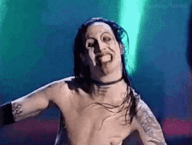 a man without a shirt is making a funny face with his tongue sticking out