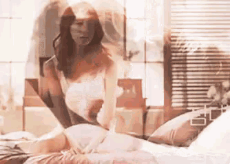 a woman in a veil is laying on a bed with a pillow .