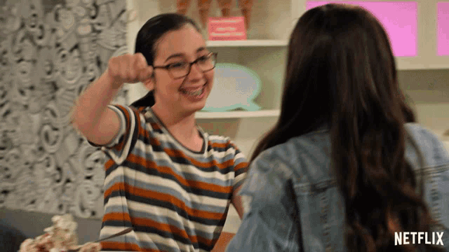 a girl wearing glasses and braces talks to another girl with a netflix logo in the corner