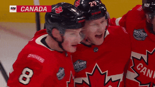 a hockey player with the number 8 on his jersey is hugging another hockey player