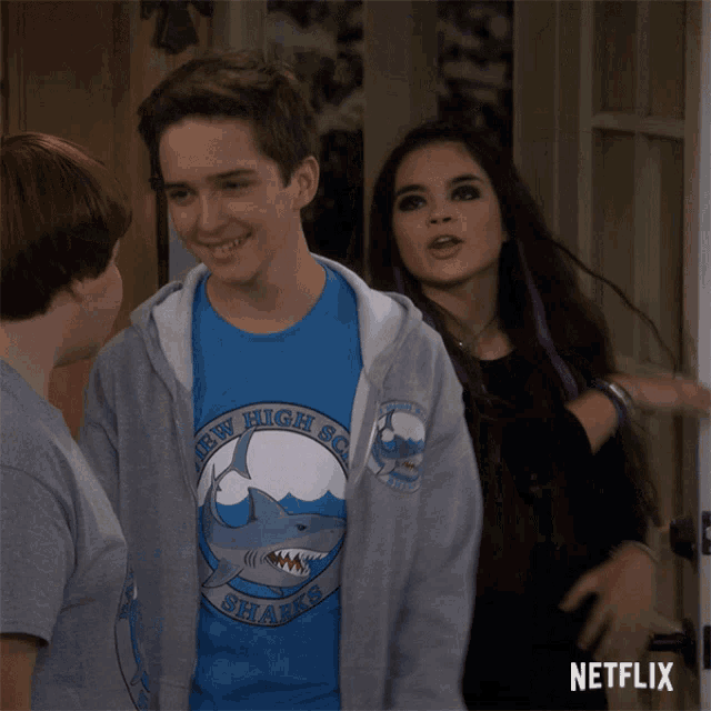 a boy and a girl standing next to each other with a netflix logo on the bottom right