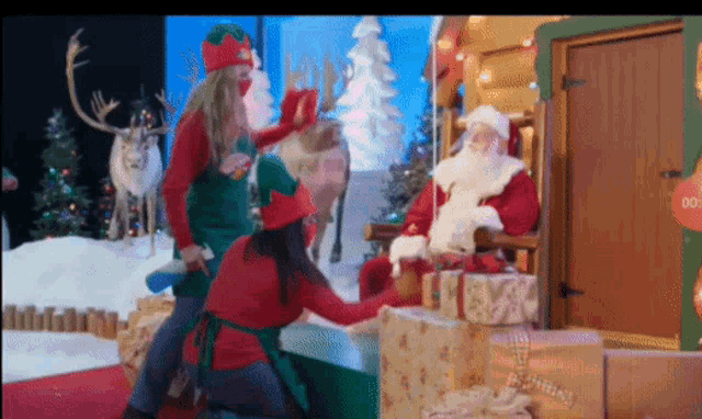 a group of people dressed as elves are kneeling in front of santa