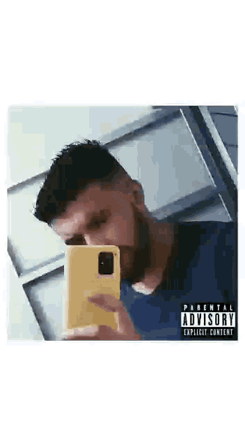 a man with a beard is taking a selfie with a parental advisory sticker on his phone .