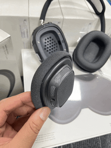 a person is holding a pair of headphones in their right hand
