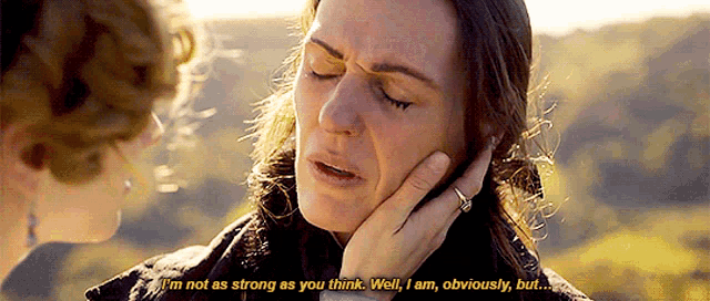 a woman is crying and holding her face while another woman says i 'm not as strong as you think