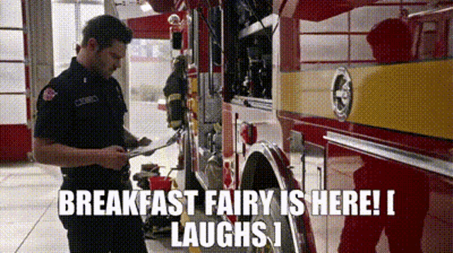a firefighter is standing in front of a fire truck in a garage .