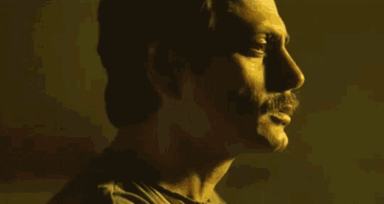 a man with a mustache is looking to the side