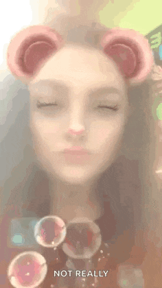 a woman wearing a bear ear filter with soap bubbles coming out of it .