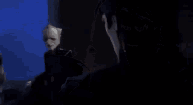 a group of cartoon characters are standing next to each other in a dark room and looking at each other .