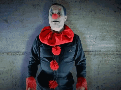 a man dressed in a clown costume with red pom poms