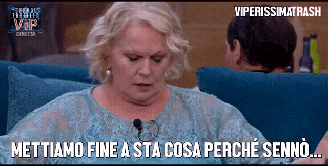 a woman sitting on a couch with the words mettiamo fine a sta cosa perche senno written below her