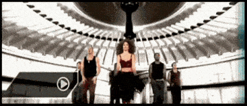 a group of people are dancing in a room with a play button in the corner