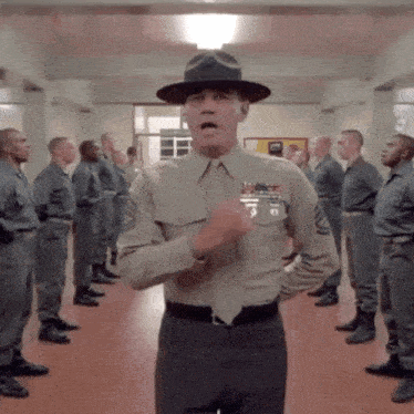 a man in a military uniform stands in front of a group of men