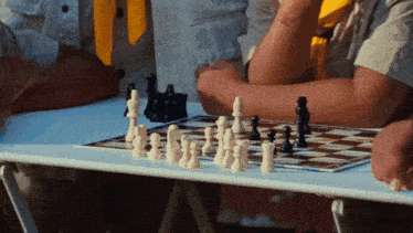 a group of people are playing chess on a table