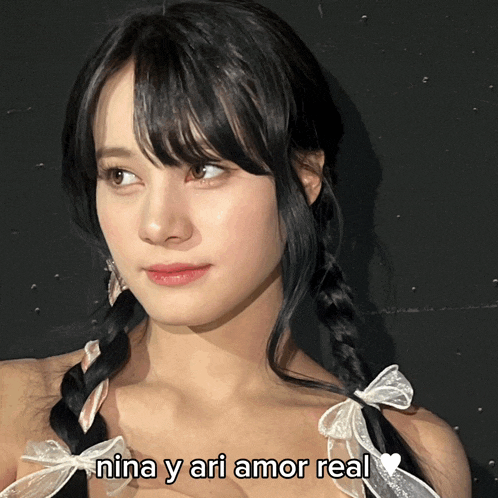 a girl with pigtails and the words nina y ari amor real on the bottom