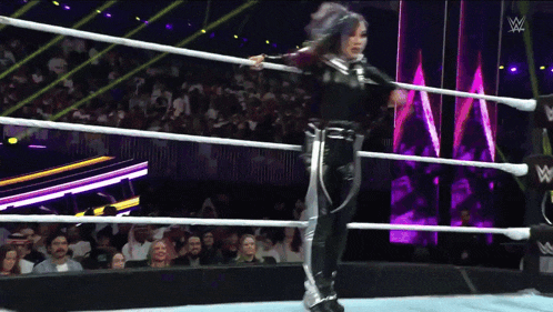a woman in a wrestling ring with a w logo on the ring