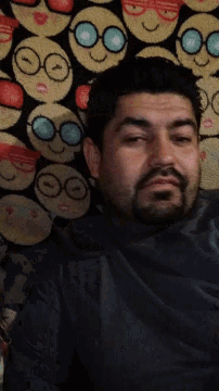 a man with a beard is laying on a blanket with smiley faces