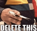 a man is holding a piece of paper in his hand with the words `` delete this '' written on it .