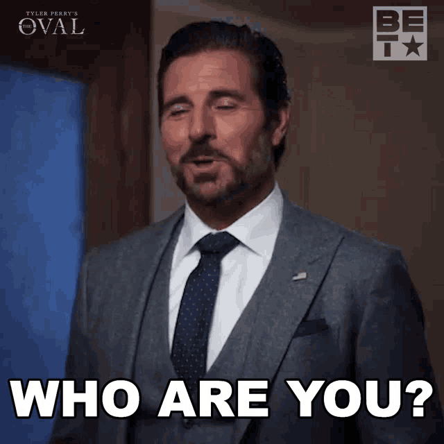 a man in a suit says who are you