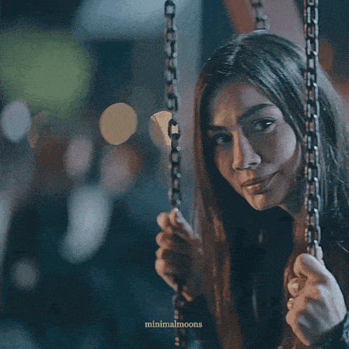 a woman is crying while sitting on a chain swing
