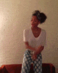 a woman is sitting on a couch wearing polka dot pajamas .