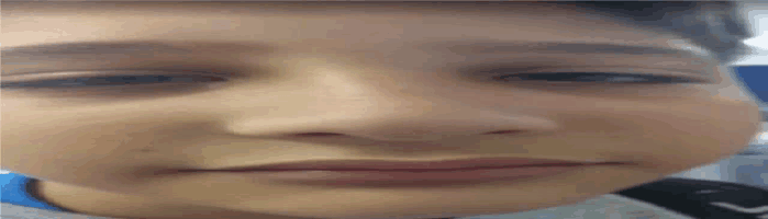 a close up of a young boy 's face with a slight smile