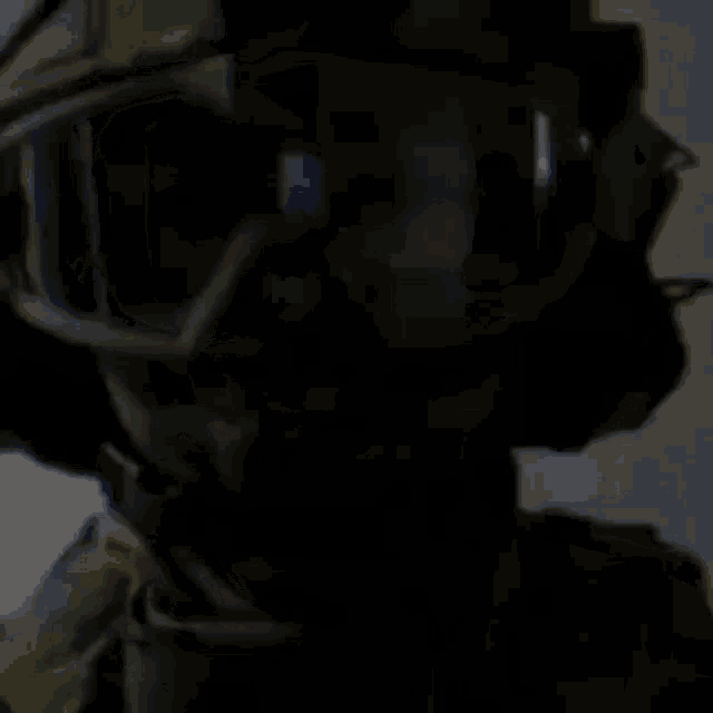 a person wearing a helmet and goggles is standing in the dark