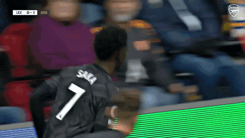 a soccer player wearing a black jersey with the number 7 on the back