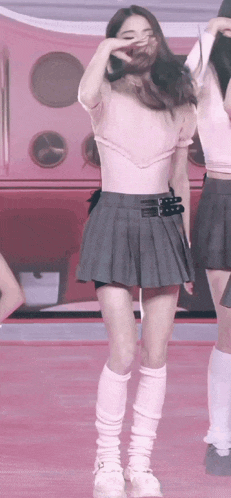 a woman in a pleated skirt and knee high socks