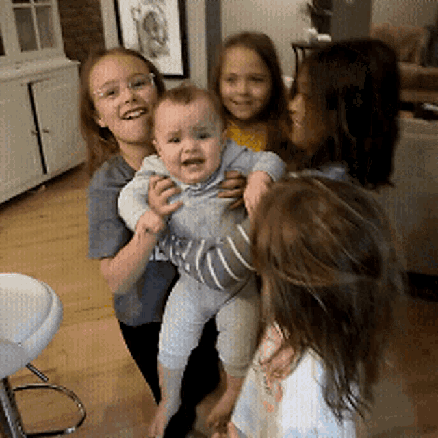 a girl is holding a baby in her arms and smiling