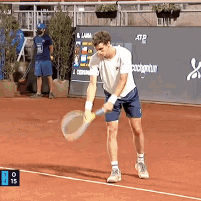 a man is holding a tennis racquet on a tennis court with a sign that says cachantun in the background