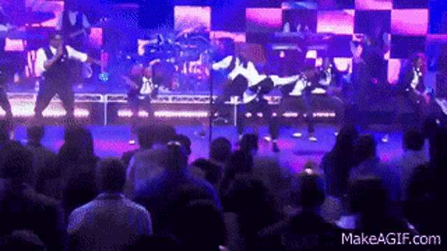 a group of people are dancing on a stage with makeagif.com in the lower right corner