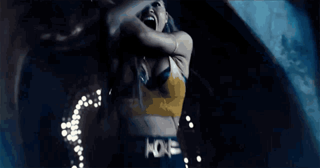 a woman with long hair is screaming with her mouth open in a dark room .