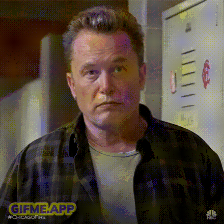 a man in a plaid shirt is making a funny face while standing in front of a locker .